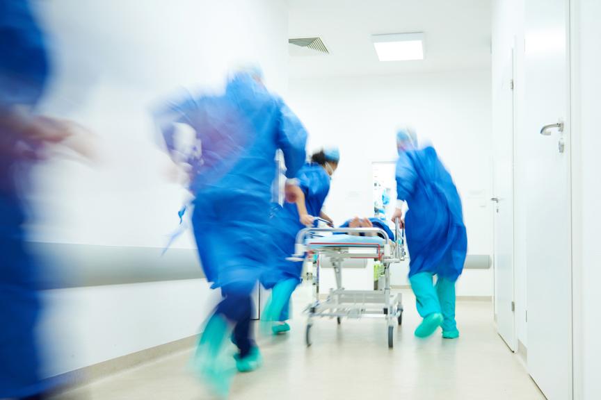Doctors hurrying a patient down a hospital floor