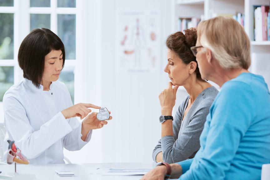 Female doctor explaining a device to a woman and a man