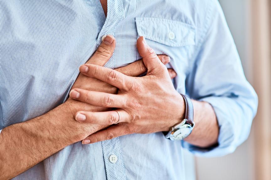 A man pressing against his chest with both hands