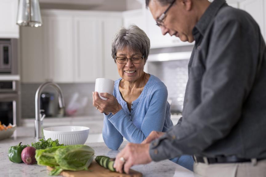A woman and a man in the kitchen preparing a salad