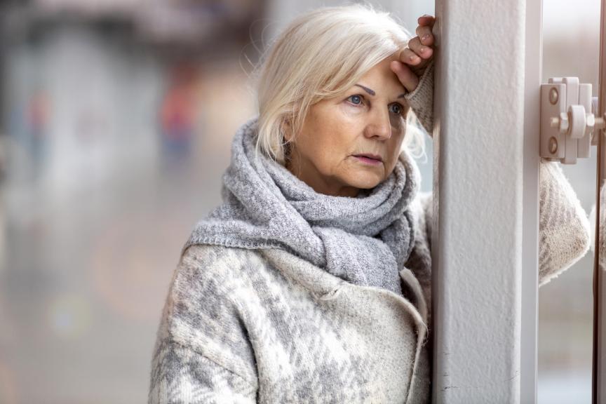 Woman leaning against a pole