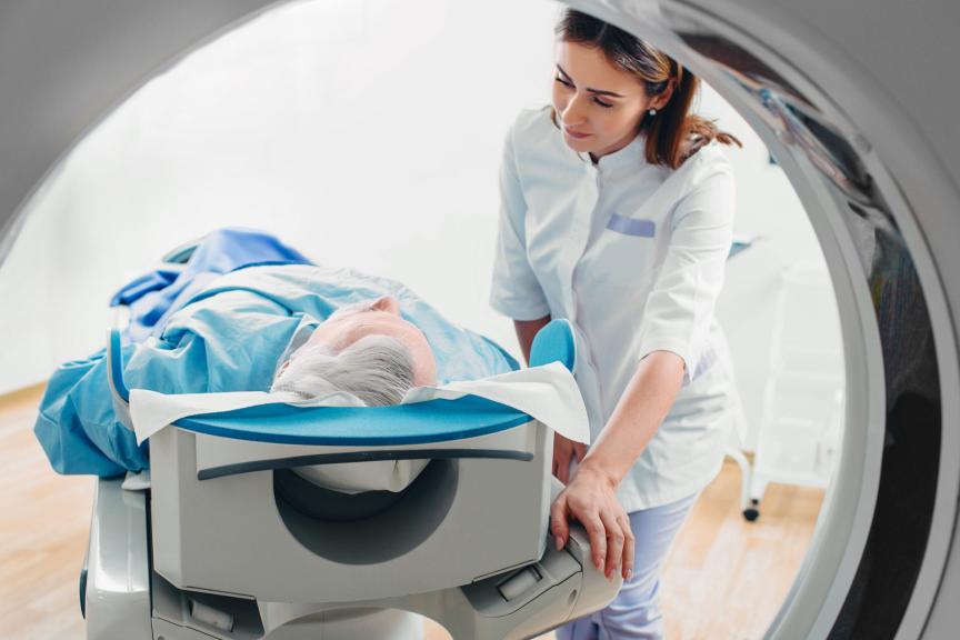 A female health care professional helping a male patinet into an MRI