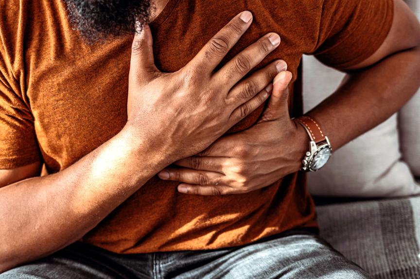 Man clutching his chest with both hands