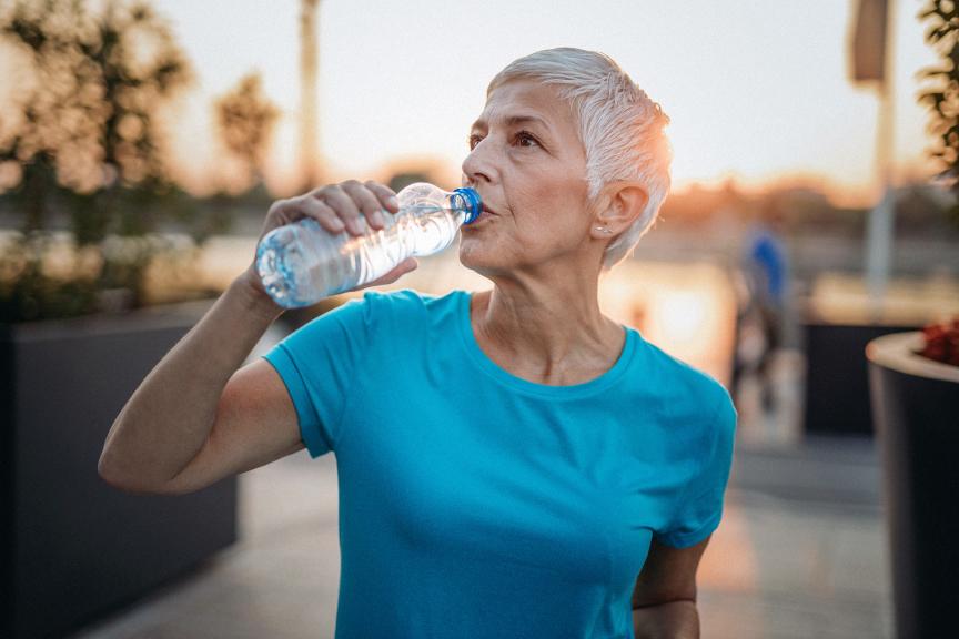 Older woman drinking water out of a bottle