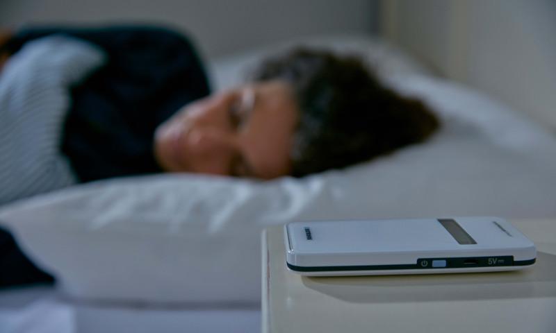 BIOTRONIK HeartInsight Patient sleeping in bed with BIOTRONIK CardioMessenger on her nightstand
